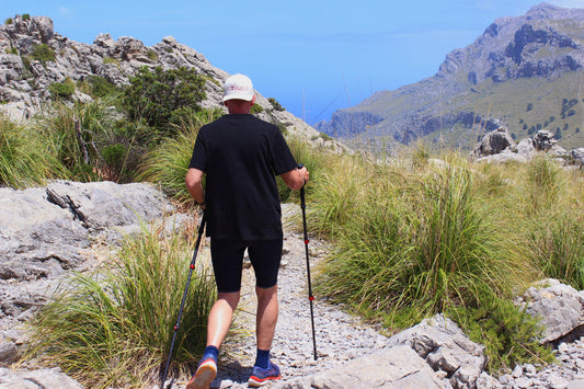Wanderer mit Rothwild Wanderstöcken auf einem Bergpfad